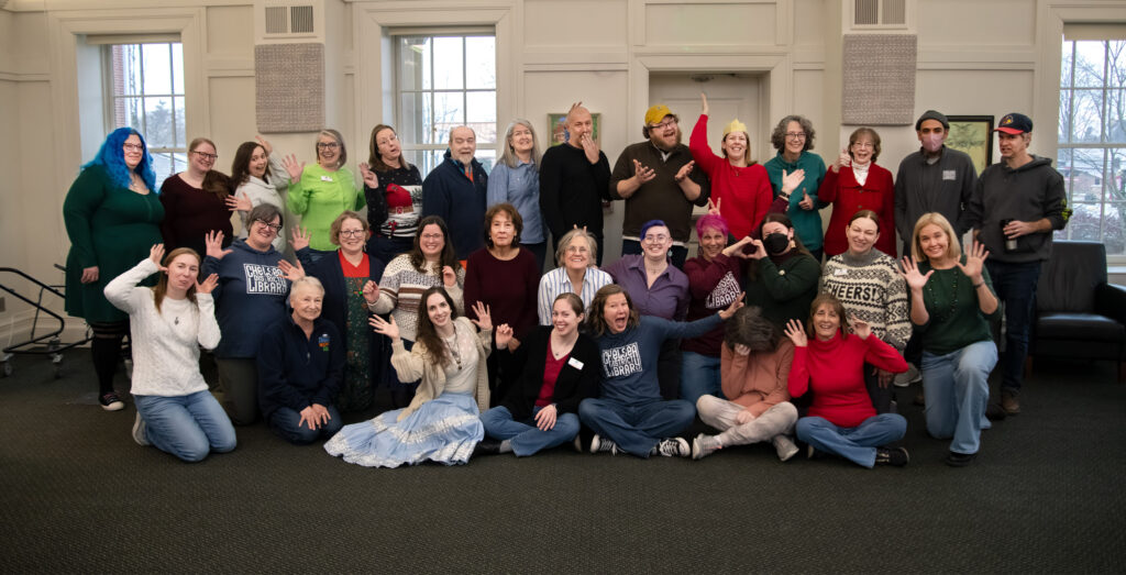 Candid image of library staff in funny poses in the historic McKune Room